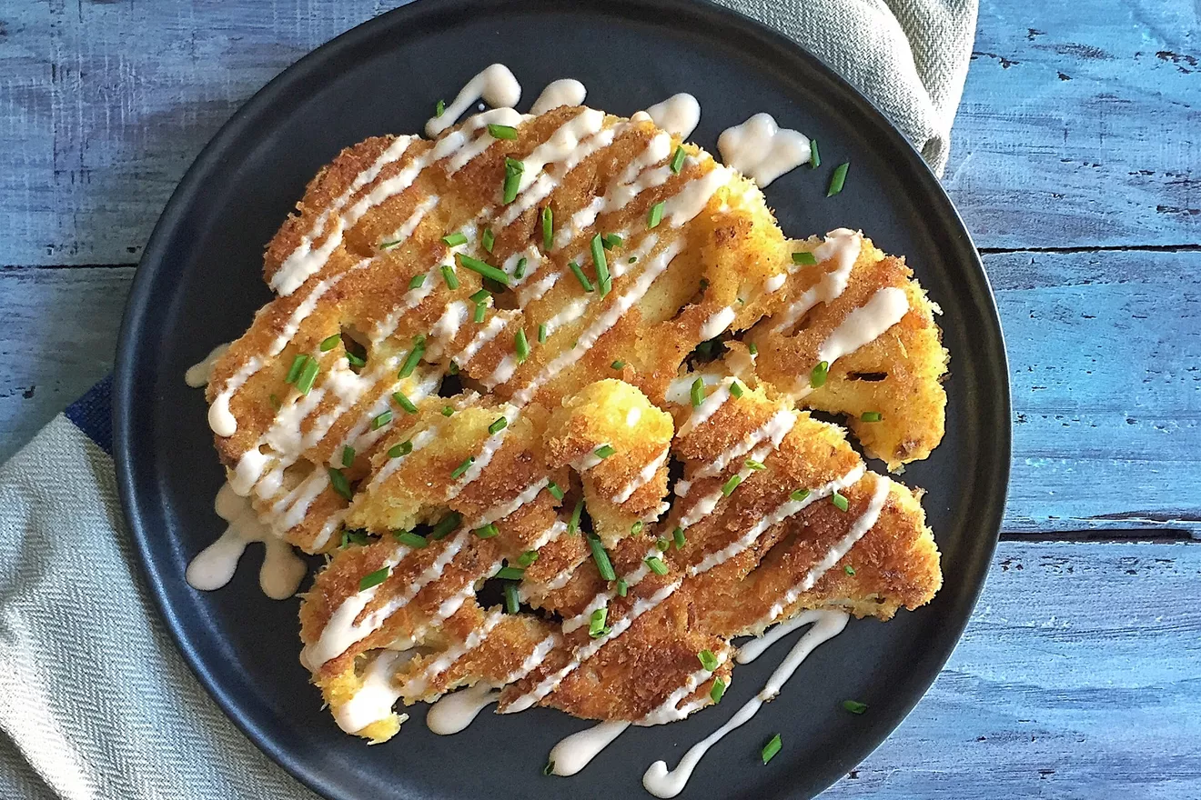 Crispy Herb-Crusted Cauliflower Steaks with Lemon-Caper Sauce on a platter