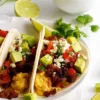 Spicy Chorizo Breakfast Tacos topped with avocado and queso fresco