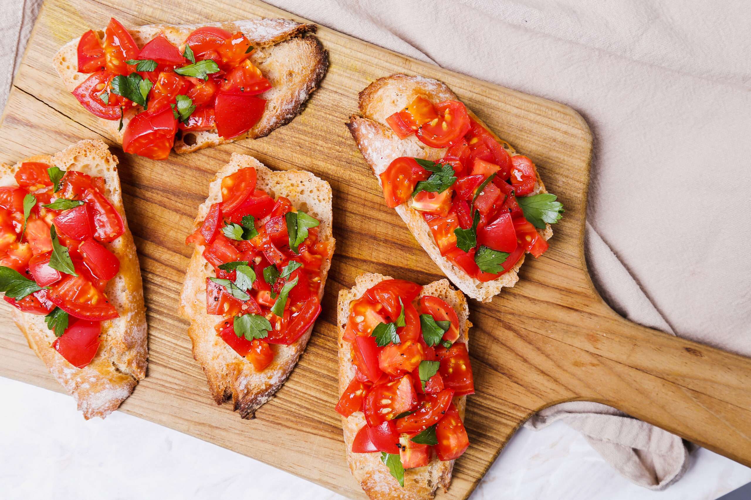 Toasted baguette slices topped with fresh tomatoes, basil, and olive oil.