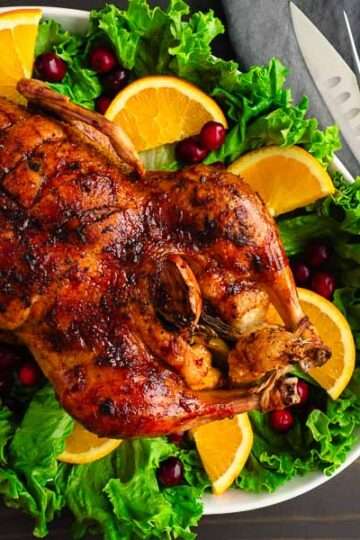 Maple-Glazed Roast Duck with Orange-Cranberry Sauce on a festive platter