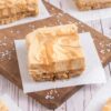 Squares of salted dulce de leche cheesecake bars with a drizzled caramel top