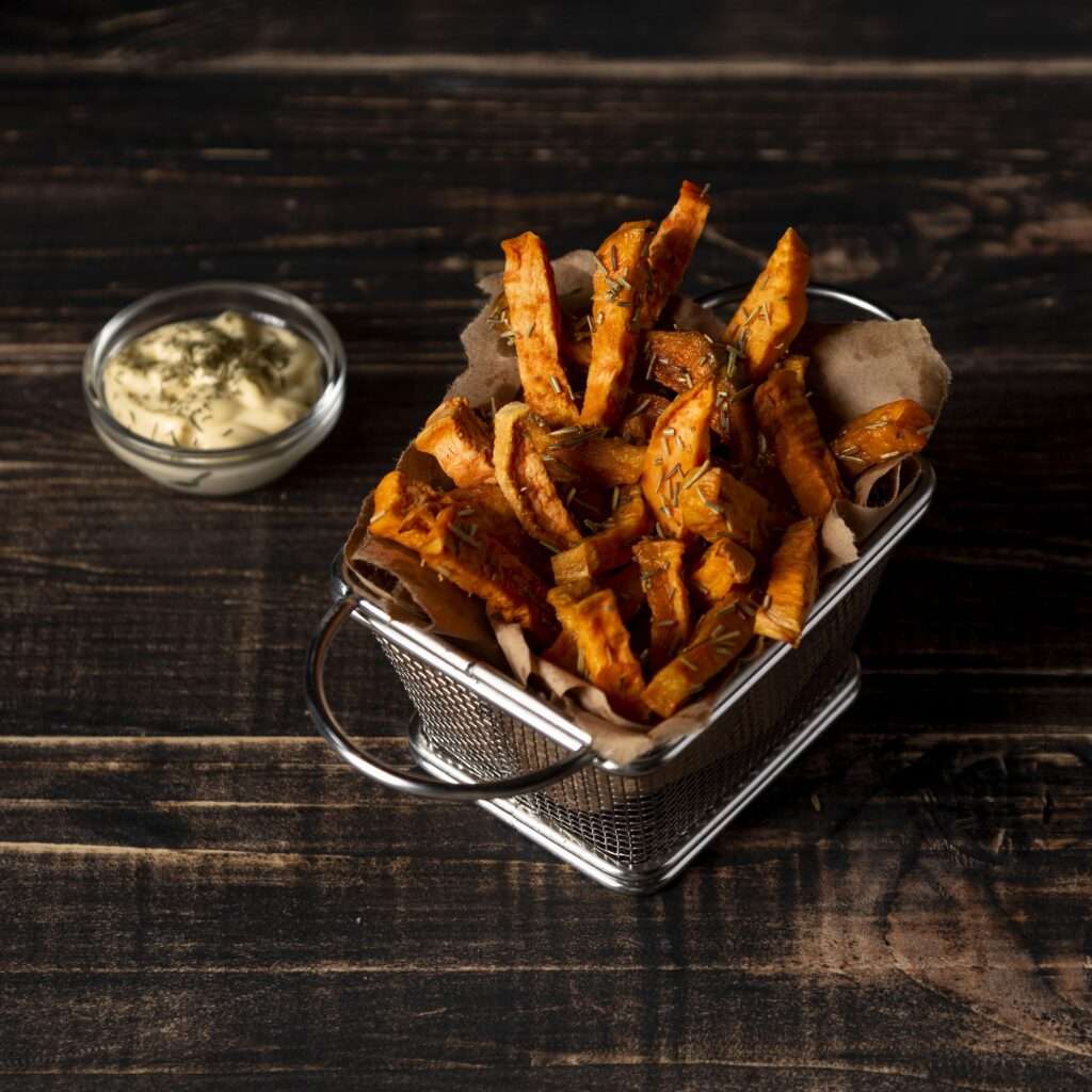 Crispy baked sweet potato fries with a spicy seasoning, served with a dipping sauce.