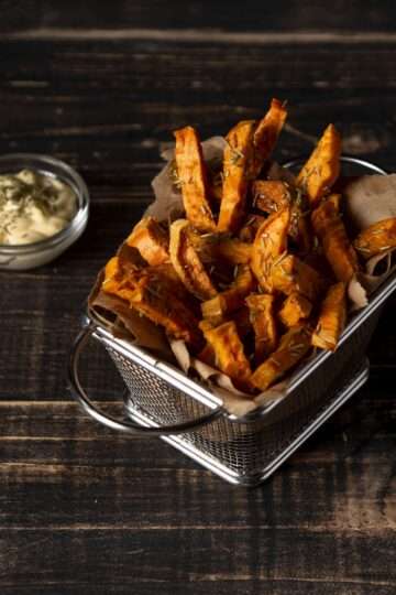 Crispy baked sweet potato fries with a spicy seasoning, served with a dipping sauce.