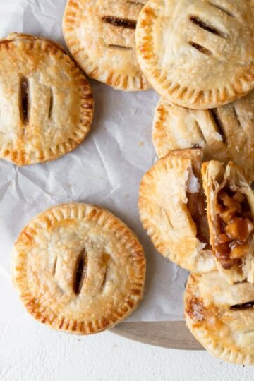 Salted Caramel Apple Hand Pies sprinkled with flaky salt on a board