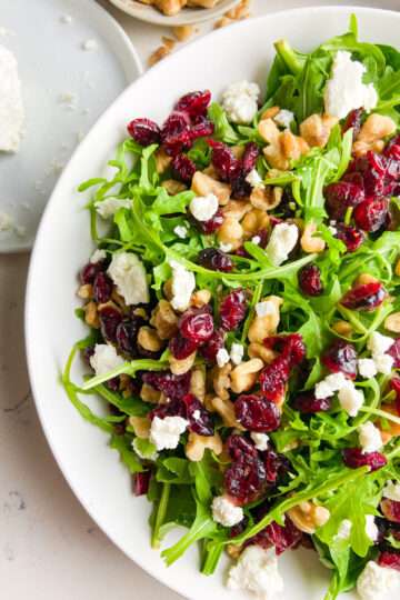 Cranberry Goat Cheese Arugula Salad in a white bowl