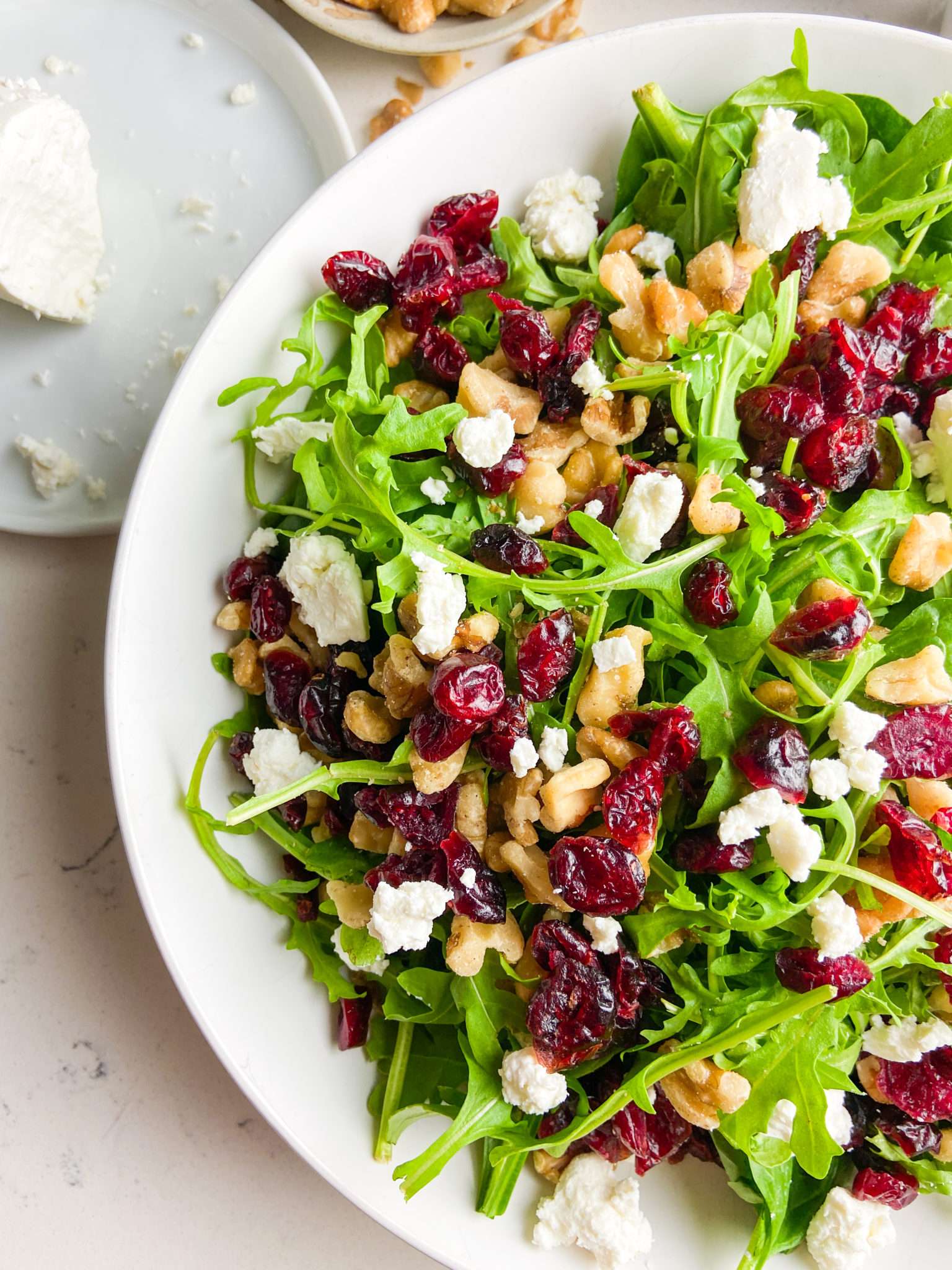 Cranberry Goat Cheese Arugula Salad in a white bowl