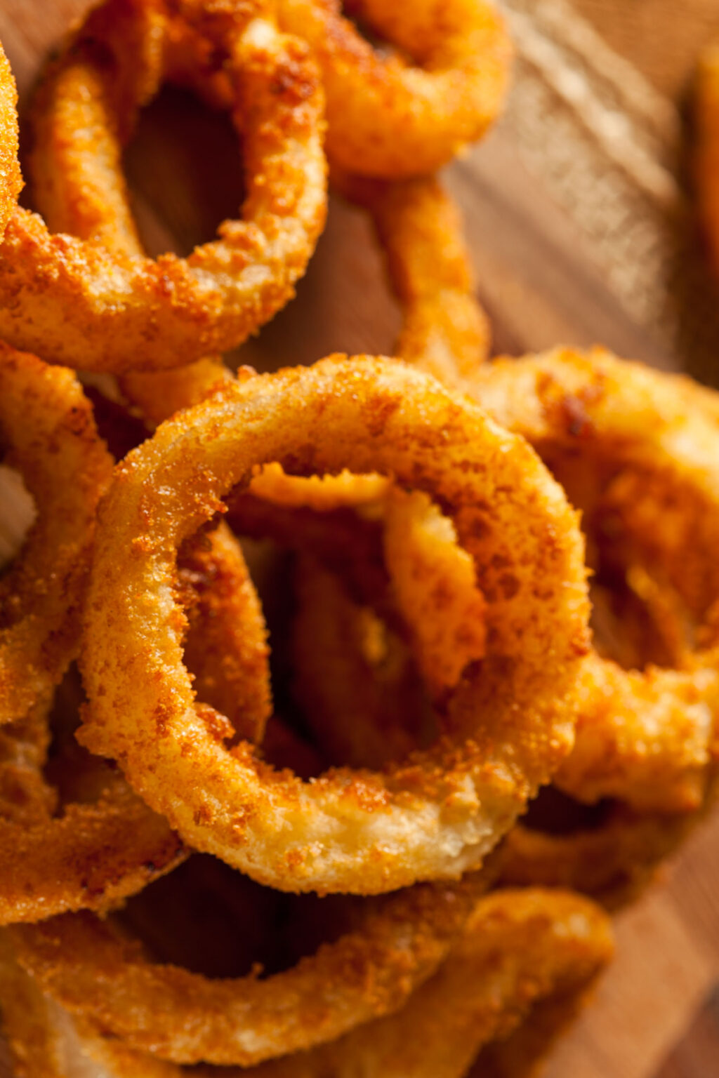 Crispy baked onion rings stacked high, with dipping sauce on the side