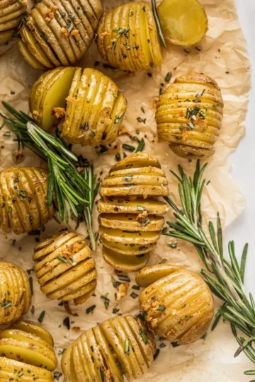 Rosemary Garlic Hasselback Potatoes sliced thinly, roasted golden-brown, and garnished with fresh rosemary