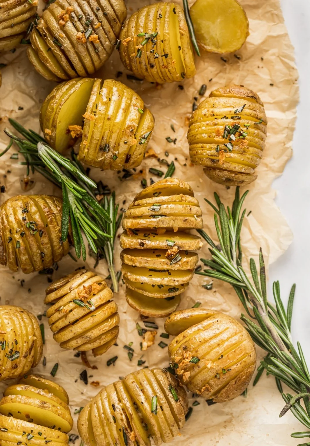 Rosemary Garlic Hasselback Potatoes sliced thinly, roasted golden-brown, and garnished with fresh rosemary