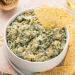 Spinach Artichoke Dip with melted cheese on top, ready for dipping.