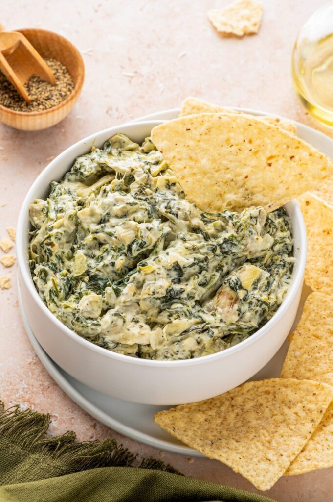 Spinach Artichoke Dip with melted cheese on top, ready for dipping.