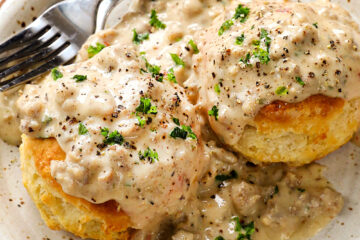 A plate of tall buttermilk biscuits and sausage gravy.