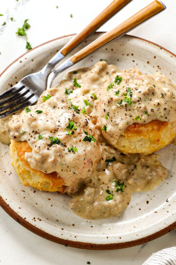 A plate of tall buttermilk biscuits and sausage gravy.