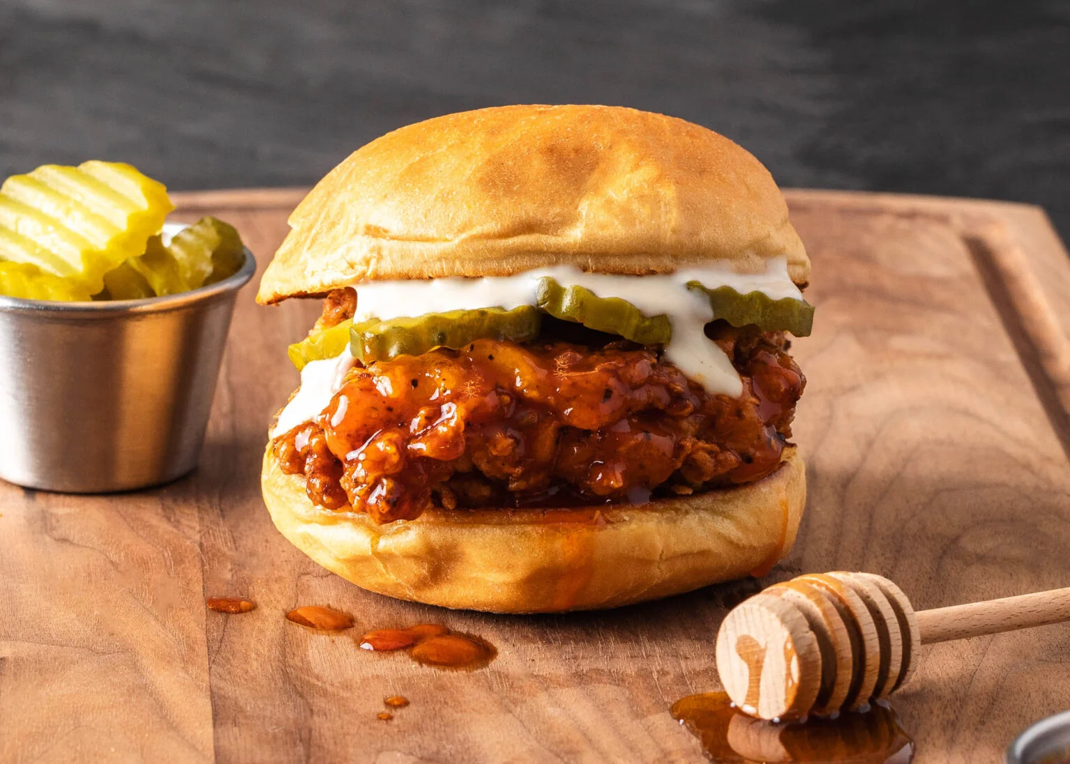 Hot Honey Crispy Chicken Sandwich with golden fried chicken thigh, pickles, and a drizzle of spicy honey.