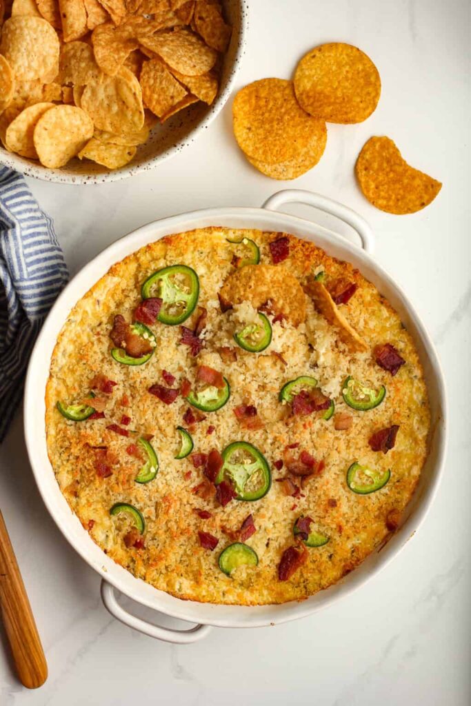 Jalapeño Popper Dip topped with melted cheese and sliced jalapeños.