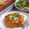 A slice of spinach ricotta lasagna with bubbly cheese on top