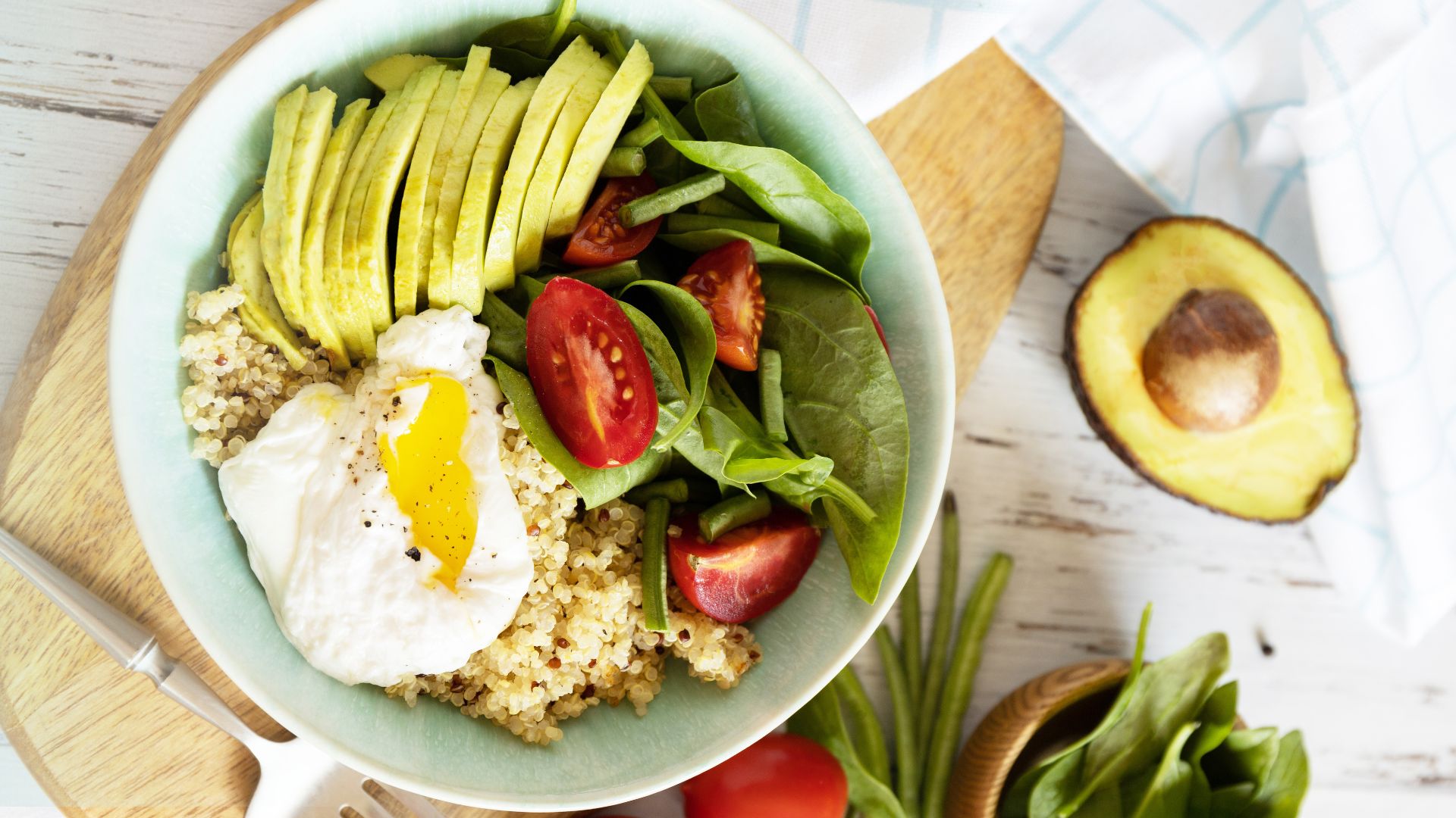 Quinoa Breakfast Bowl topped with poached eggs, fresh spinach, and a squeeze of lemon