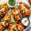 Loaded Potato Skins topped with melted cheddar, crispy bacon, green onions, and sour cream