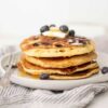 Nutrient-Packed Sourdough Pancakes topped with blueberries, banana slices, and a drizzle of maple syrup