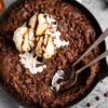 Triple Chocolate Brownie Skillet topped with melting vanilla ice cream